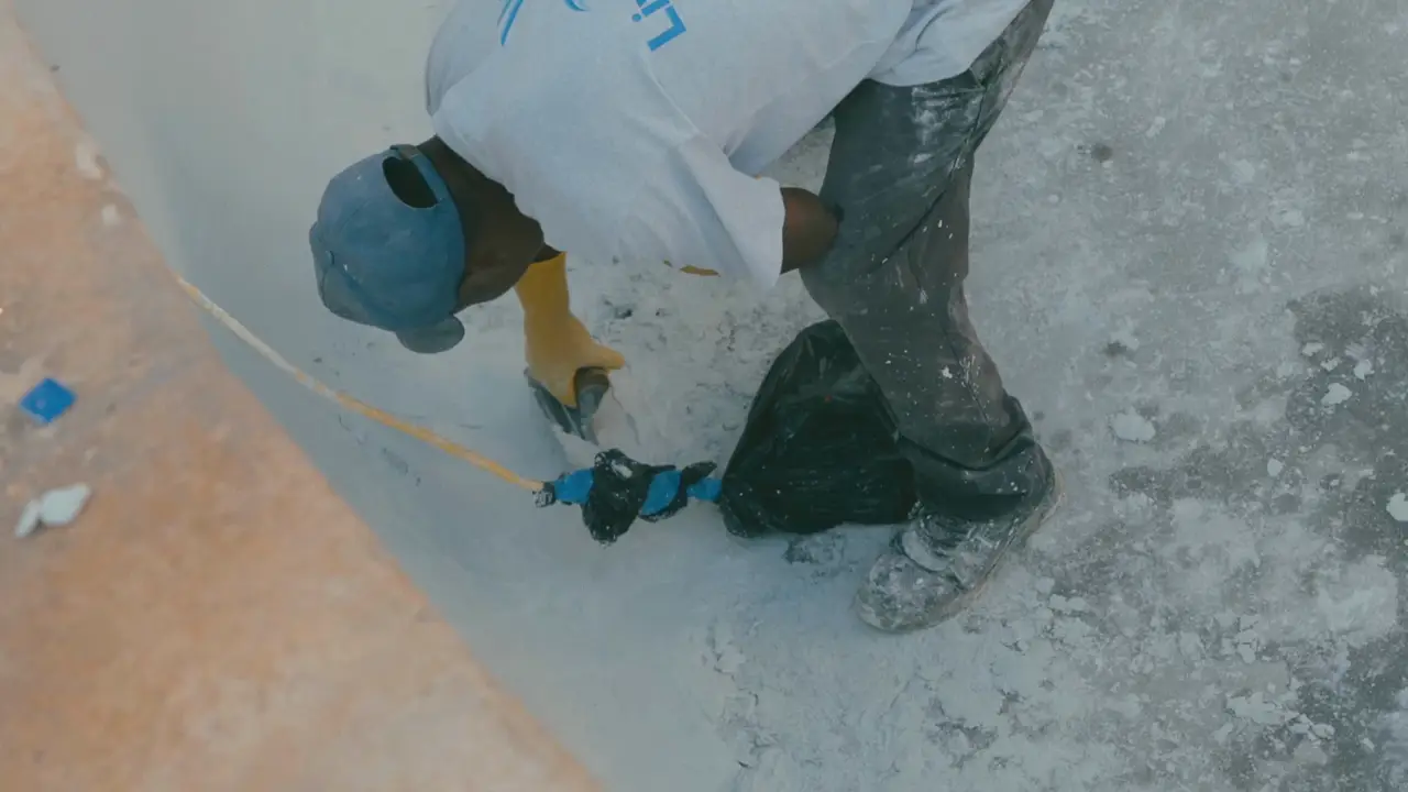 Living Water Aruba technicians plastering the wall of an empty pool during a renovation